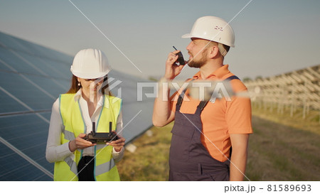 Portrait of a female engineer operating a drone on the background of a solar power plant. Photovoltaic solar panel installation. Solar array. New technologies. Investor and worker engineer Portrait of a female engineer operating a drone on the background of a solar power plant. Photovoltaic solar panel installation. Solar array. New technologies. Investor and worker engineer 81589693