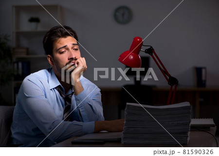 Young male employee working late in the office 81590326