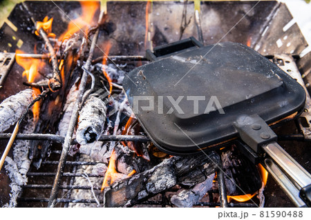 キャンプ場での朝の焚き火とホットサンドメーカーでの朝食作り 81590488