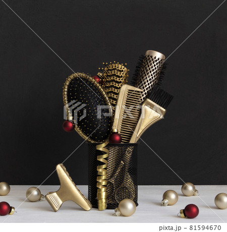 Hairdressing golden combs, brush and scissors in a stand. Hair salon accessories and Christmas balls. Hairdressing golden combs, brush and scissors in a stand. Hair salon accessories and Christmas balls. 81594670