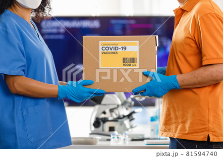 Asian man handling a box of Covid 19 vaccine to Asian nurse in hospital. Concept for Covid 19 vaccination. 81594740