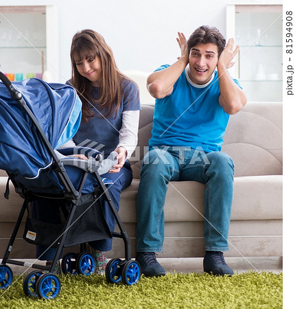 Young parents with their newborn baby in baby pram sitting on th 81594908