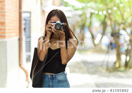 Female tourist photographer taking picture with vintage camera 81595892
