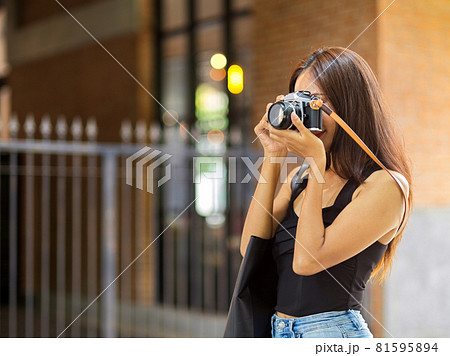 Female freelancer photographer taking picture with film camera 81595894