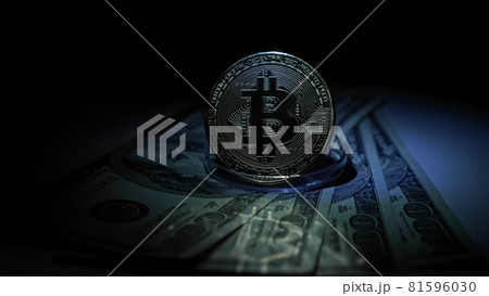 Gold bitcoin on a stand stands on dollar bills 81596030