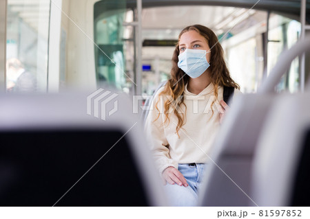 Young lady in face mask riding on tram to her work Young lady in face mask riding on tram to her work 81597852