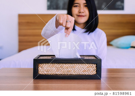 Happy asian woman hands pulling white tissue paper from wooden box 81598961