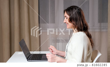 Young woman in white sweater and black headphones chats Young woman in white sweater and black headphones chats 81602285