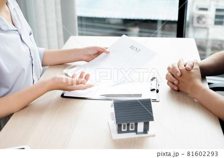A real estate agent with a home model is talking to clients about renting a home and buying home insurance. Home rental and insurance concept A real estate agent with a home model is talking to clients about renting a home and buying home insurance. Home rental and insurance concept 81602293