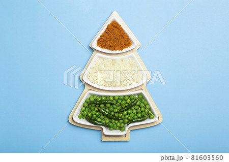 Indian flag in the shape of a new year christmas tree made from food background. Basmati rice, curry, green peas and chili peppers in the colors of the Indian flag and Christmas tree on a blue Indian flag in the shape of a new year christmas tree made from food background. Basmati rice, curry, green peas and chili peppers in the colors of the Indian flag and Christmas tree on a blue 81603560