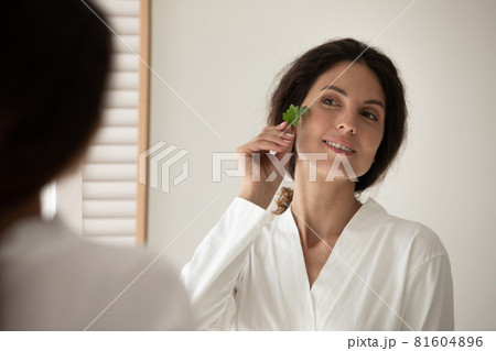Young attractive hispanic woman holding parsley near face. Young attractive hispanic woman holding parsley near face. 81604896