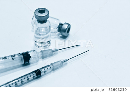 Vial of drugs or vaccine and plastic syringe with needle isolated on the white background, blue tone color Vial of drugs or vaccine and plastic syringe with needle isolated on the white background, blue tone color 81608250