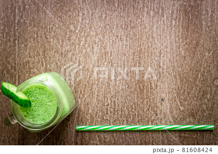 Glass of spinach juice on wooden background 81608424