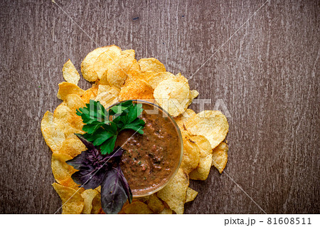 Potato chips with dipping sauce on a wooden table. Unhealthy food on a wooden background. 81608511
