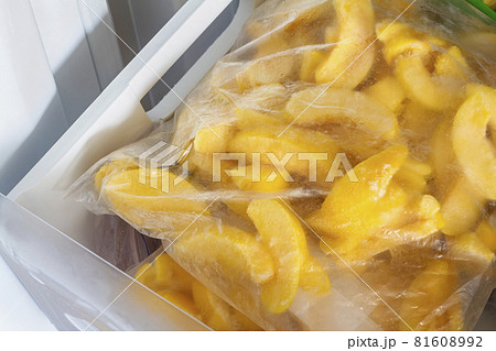 Frozen quince in transparent plastic bags in the freezer. Open deep freeze with frozen quince. Concept of healthy eating Frozen quince in transparent plastic bags in the freezer. Open deep freeze with frozen quince. Concept of healthy eating 81608992