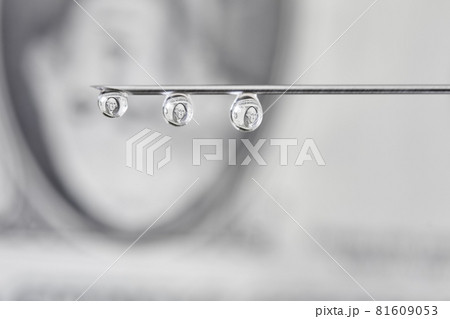 On the needle of the american dollar. Drops flows from the syringe needle with the reflection of dollar. Concept of investment, the cost of drugs and treatment, drug addiction, corruption. 81609053