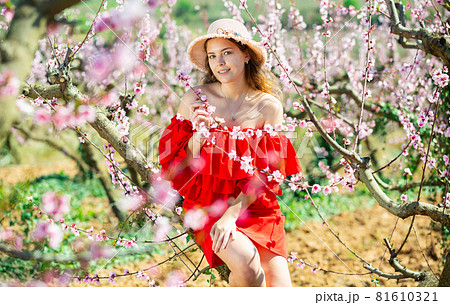 Young girl standing in spring blooming garden 81610321