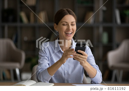 Excited businesswoman looking at phone screen, reading good news 81611192