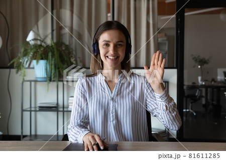 Head shot portrait smiling businesswoman in headphones waving hand 81611285