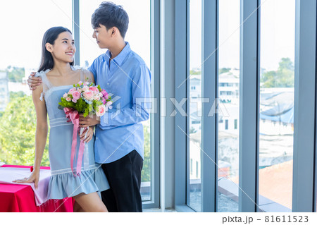 Valentine's day concept,asian Young happy sweet couple holding bouquet of red and pink roses After lunch In a restaurant background,Love story couple 81611523