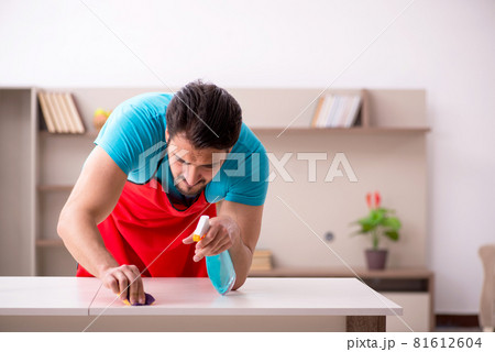 Young male contractor cleaning the house Young male contractor cleaning the house 81612604