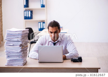 Young male employee unhappy with excessive work Young male employee unhappy with excessive work 81612687