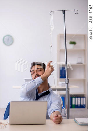 Young male employee suffering at workplace Young male employee suffering at workplace 81613507