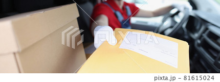 Man delivering yellow envelope from car closeup Man delivering yellow envelope from car closeup 81615024