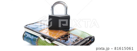 Metal padlock standing on multi-colored leather wallet closeup 81615061