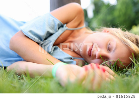 Young drunk woman sleeping in green grass Young drunk woman sleeping in green grass 81615829
