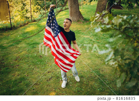 Top view portrait of young handsome man holding flag of America Top view portrait of young handsome man holding flag of America 81616835
