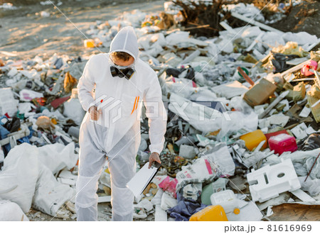 Researcher looking at plastic landfill analyzing environmental pollution level Researcher looking at plastic landfill analyzing environmental pollution level 81616969