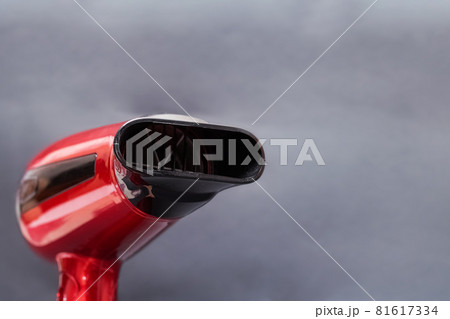 Red hair dryer on a gray background Red hair dryer on a gray background 81617334
