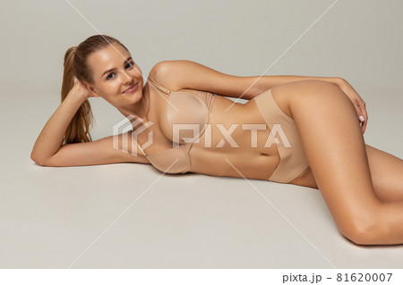 Young beautiful woman in cotton beige underwear on pastel background 81620007