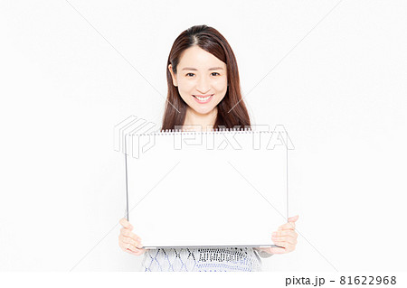 大きいスケッチブックを持って案内をするカジュアルな服を着ている女性 81622968