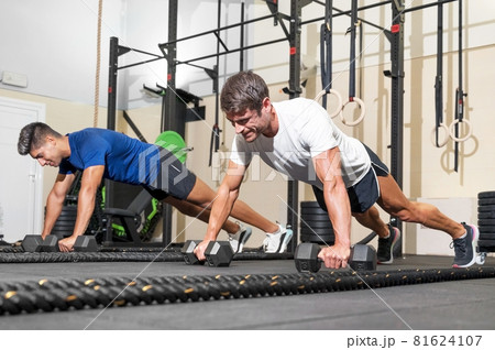 Two strong men doing push-ups in gym. 81624107