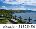 遠くに雪の残る山々と海岸沿いにある柵とベンチ【北海道　神威岬5月】 81626450