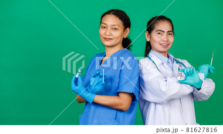 Asian female nurse in scrubs and doctor in white gown holding syringe and Covid 19 vaccine preparing for injection. Concept for Covid 19 vaccination Asian female nurse in scrubs and doctor in white gown holding syringe and Covid 19 vaccine preparing for injection. Concept for Covid 19 vaccination 81627816