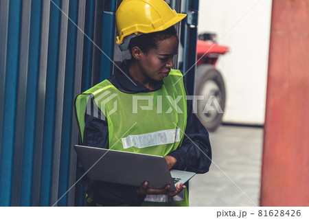Young African American woman worker at overseas shipping container yard Young African American woman worker at overseas shipping container yard 81628426
