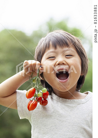 ミニトマトを持つ農家の子供 81633881