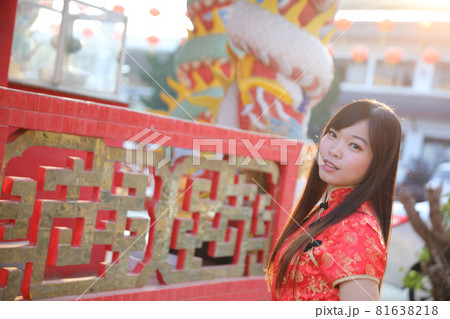 beauty woman wear red cheongsam looking and smile in chinese new year 81638218
