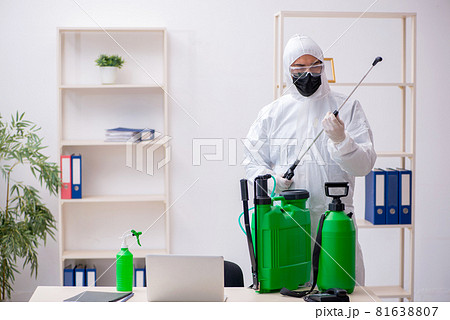 Young male contractor disinfecting office during pandemic Young male contractor disinfecting office during pandemic 81638807