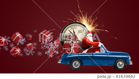 Christmas is coming. Santa Claus on toy car delivering New Year 2022 gifts and countdown clock at red background with fireworks 81639662