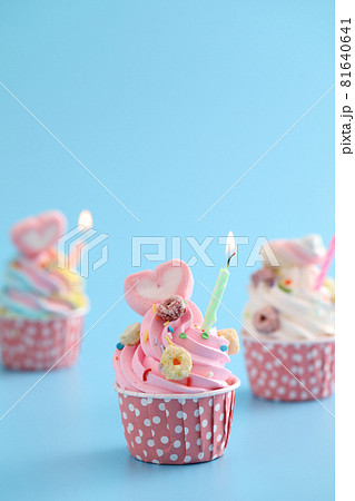 Colorful cupcakes with candle isolated in blue background Colorful cupcakes with candle isolated in blue background 81640641