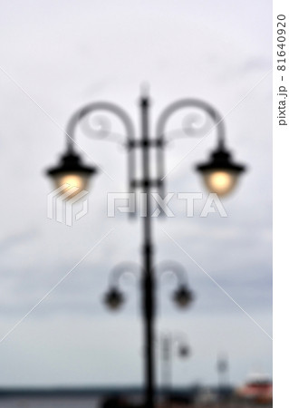 A blurred silhouette of a street lamp, a lantern shining with a voucher 81640920
