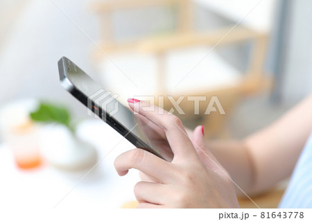Female hand with smartphone trading stocks online in coffee shop Business concept 81643778