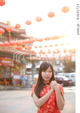 beauty woman wear red cheongsam looking and smile in chinese new year 81645724