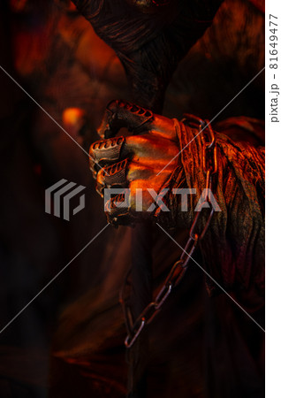 Halloween decorations, spooky creepy scary fearfull horrible terrible warlock's hand in rags with metal fingers and a chain holding frighten skull mask in bloody red orange gold colors Halloween decorations, spooky creepy scary fearfull horrible terrible warlock's hand in rags with metal fingers and a chain holding frighten skull mask in bloody red orange gold colors 81649477
