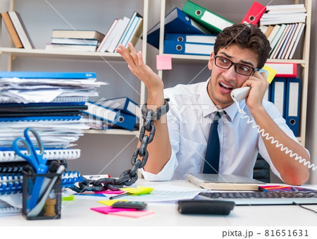 Employee attached and chained to his desk with chain 81651631