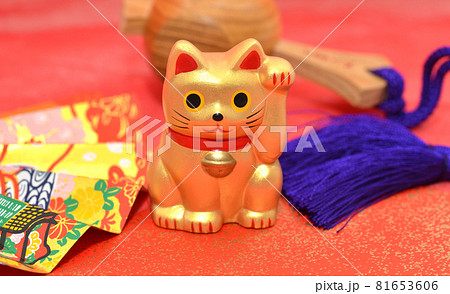 赤色バックに金色の招き猫と扇を置いた縁起物イメージ 81653606